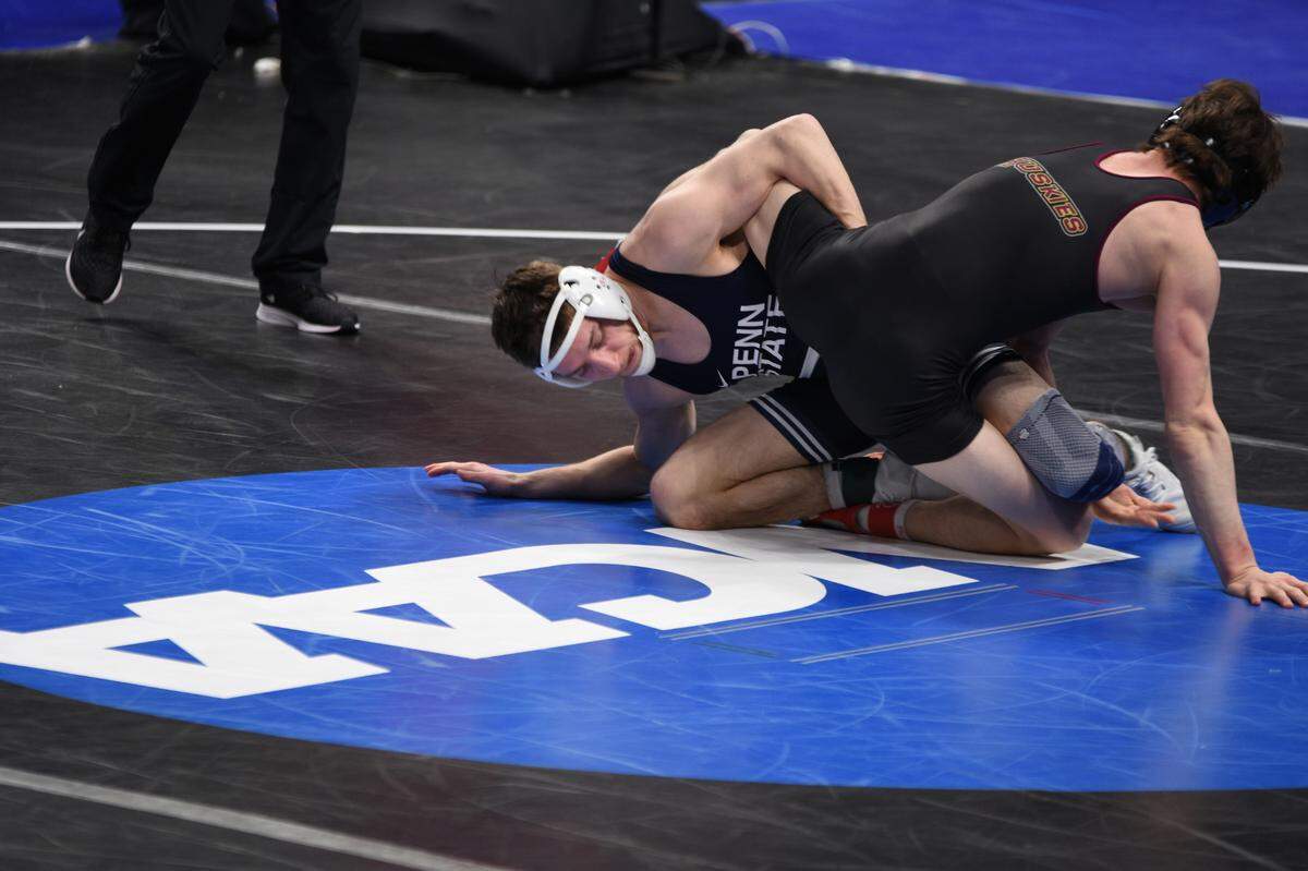 Penn State’s Nick Lee scrambles with Bloomsburg’s Josh Mason in their 141-pound first round bout of the NCAA Championships on Thursday, March 17, 2022 at Little Caesar’s Arena in Detroit. Lee topped Mason, 15-3.