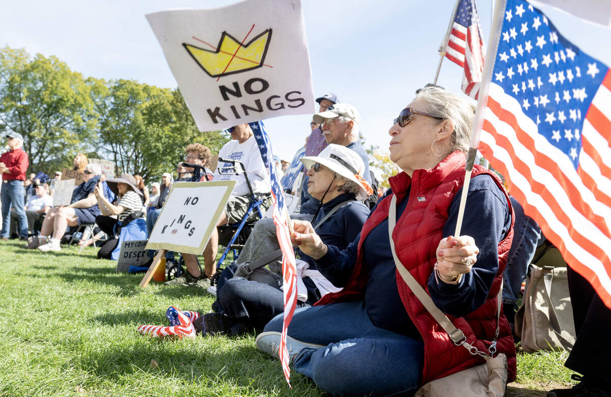 Jackie Sobel waves American flags with a No Kings sign as she listens to speakers at the No Kings anti-Trump rally on Saturday, Oct. 18, 2025.