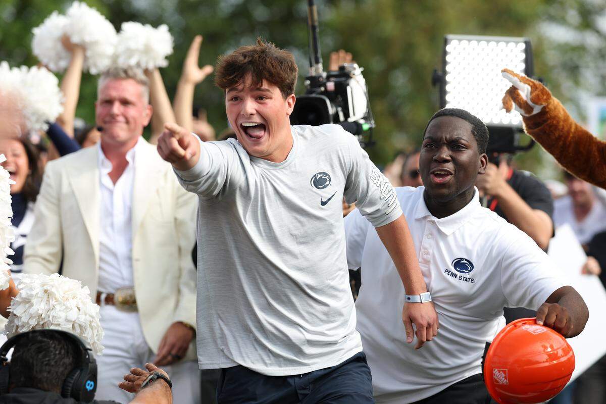 Penn State student Carson Albright points straight ahead while fellow student William looks on Saturday morning during the Field Goal Kicking Challenge segment on the set of College GameDay at Penn State. Albright nailed a 33-yard field goal to win $300,000.