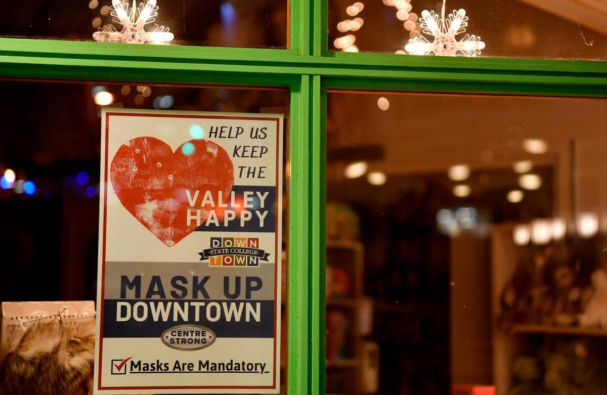 A sign in the window of the Animal Kingdom on Allen Street reminds customers to wear a mask.