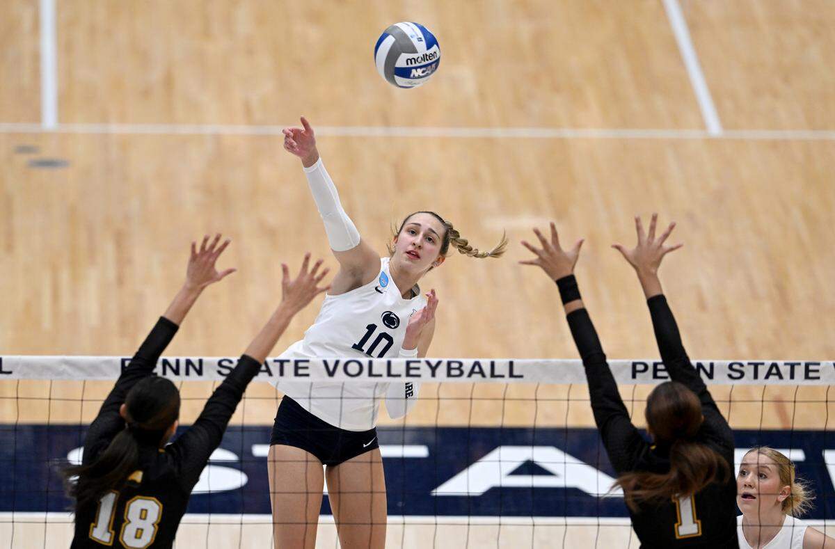Penn State Anjelina Starck hits the ball over UMBC defenders during the match in the first round of the NCAA tournament on Friday, Dec. 2, 2022 in Rec Hall.