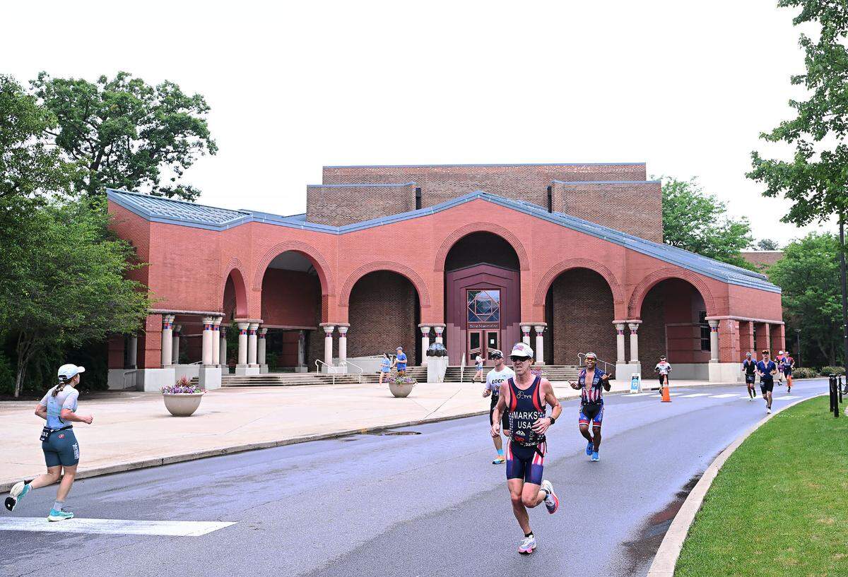 Participants in the Ironman 70.3 Pennsylvania Happy Valley run past the Palmer Art Museum on the Penn State campus Sunday, July 2, 2023.