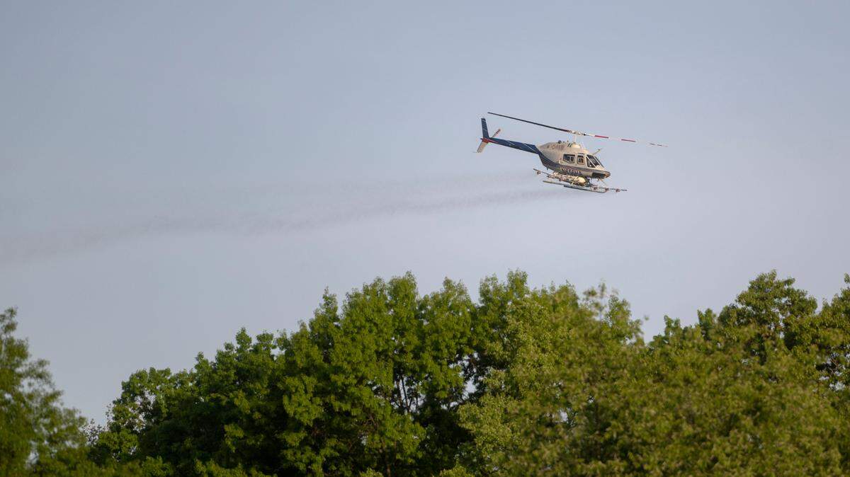 A helicopter spraying to help control spongy moth caterpillar activity passes over the Oakwood neighborhood in Patton Township on Tuesday, May 16, 2023.