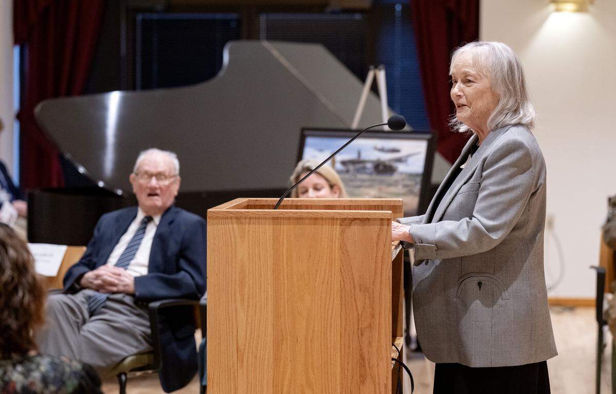 Kimberly Homan talks about her father, 101-year old World War II veteran John F. Homan, during a ceremony where he received the French Legion of Honor at Foxdale Village on Wednesday, Dec. 10, 2025.  