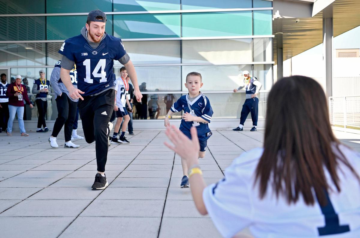 Penn State quarterback Sean Clifford races 6 year old Evan Brysiak to his sister Ashlyn, 12, on the patio of the Lasch Building on Saturday, Feb. 22, 2020.
