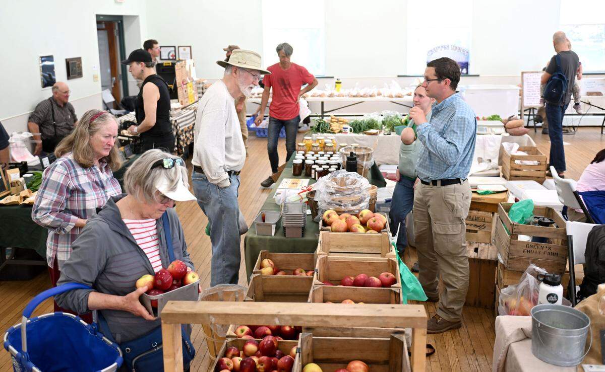Visitors browse the apples and items from Green’s Fruit Farm during the Boalsburg Farmers Market at the Boalsburg Fire Company on Tuesday, April 29, 2025. The farmers market moves outside, to the Pennsylvania Military Museum, on May 6.