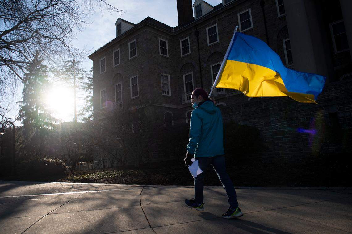 James Shin, of State College, hold a Ukrainian flag Thursday during a protest hosted by the Ukrainian Society at Penn State in front of Old Main.