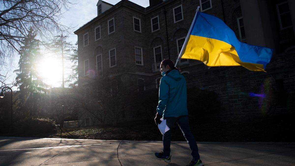 James Shin, of State College, holds a Ukrainian flag on March 3 during an anti-war protest hosted by the Ukrainian Society at Penn State in front of Old Main.