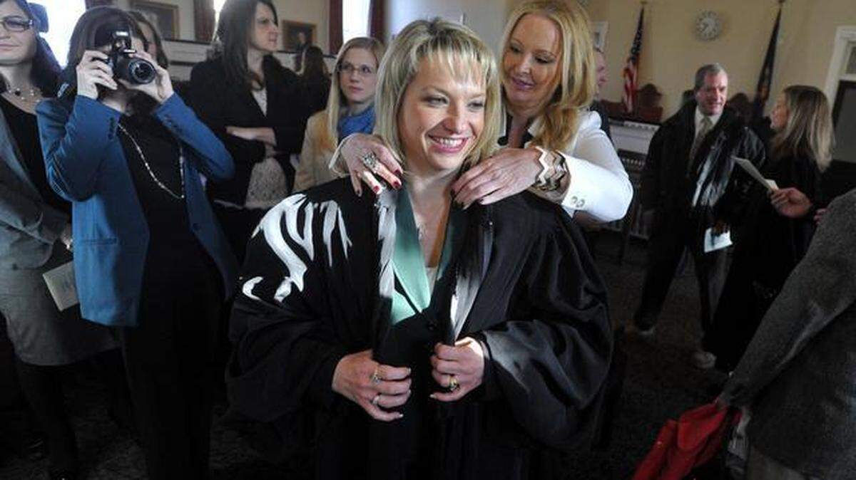 New Magisterial District Judge Kelley Gillette-Walker puts on her judge’s robe with assistance from Centre County District Attorney Stacy Parks Miller at the Centre County Courthouse on Friday, January 3, 2013.
