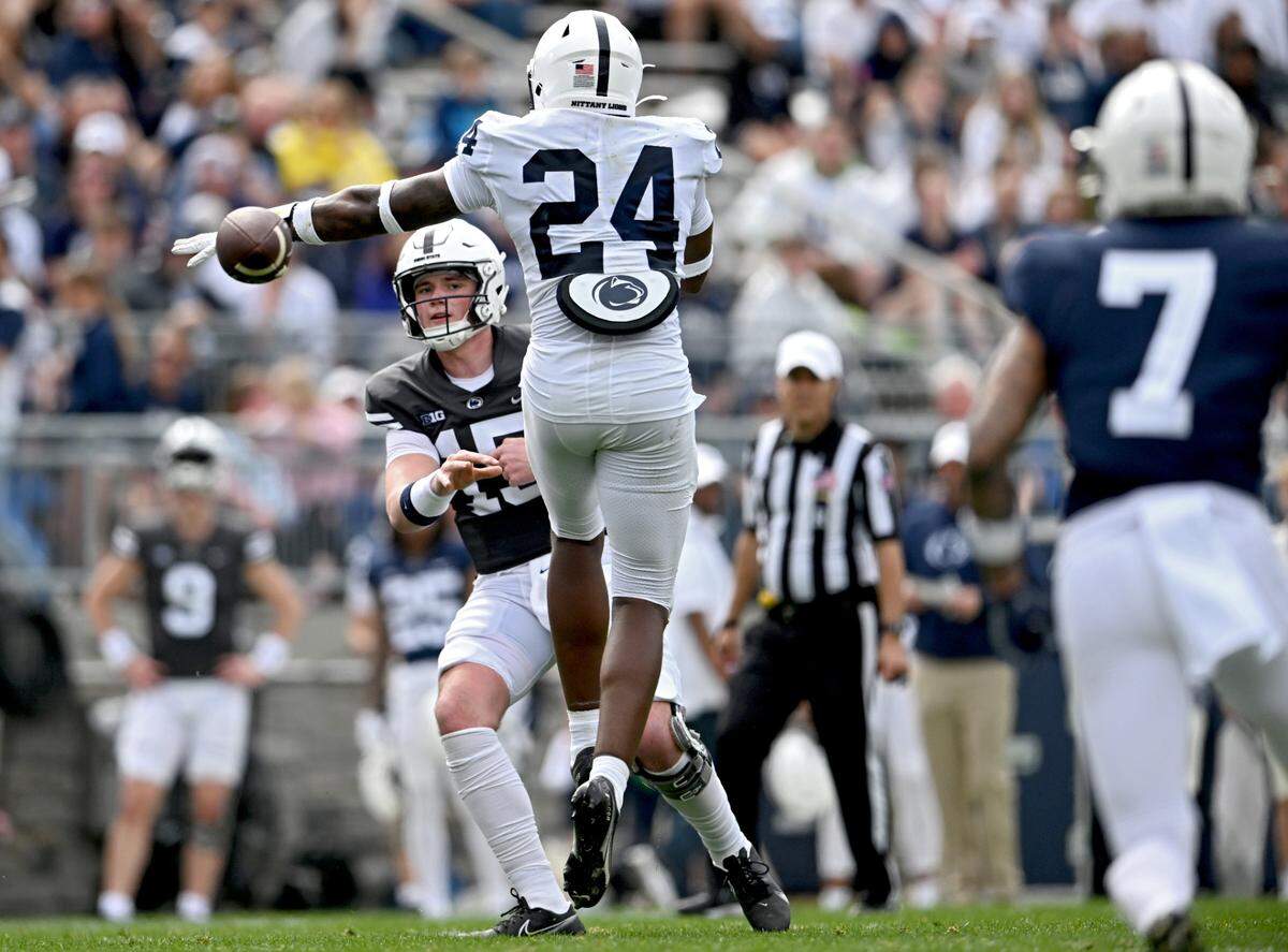 Quarterback Drew Allar makes a side arm pass around linebacker Ta’Mere Robinson to Kaden Saunders during the Penn State Blue-White game on Saturday, April 15, 2023.