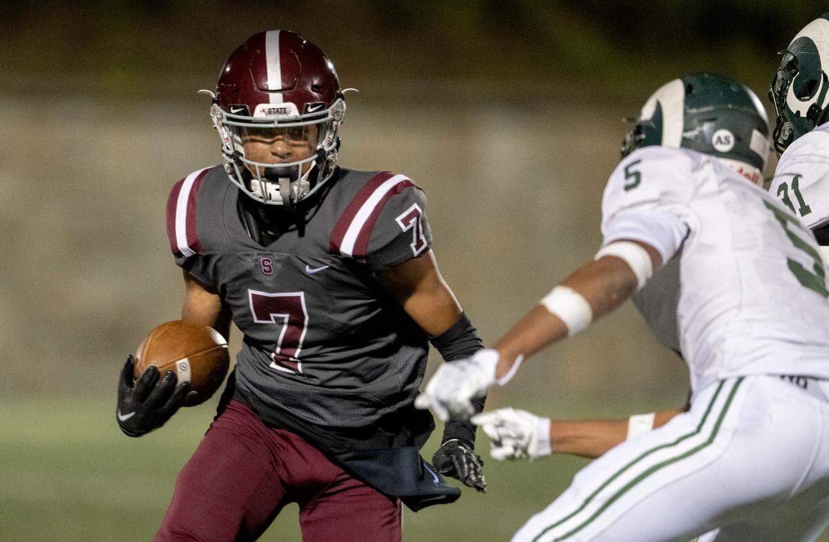 State College’s D’antae Sheffey cuts down he field with the ball from Central Dauphin defenders during the game on Friday, Sept. 23, 2022 at Memorial Field.