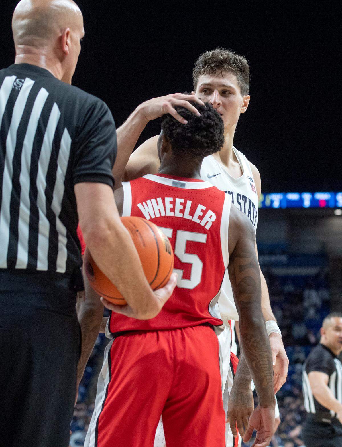 Penn State’s John Harrar jokes with Ohio State’s Jamari Wheeler after a foul during the game on Sunday, Dec. 5, 2021.