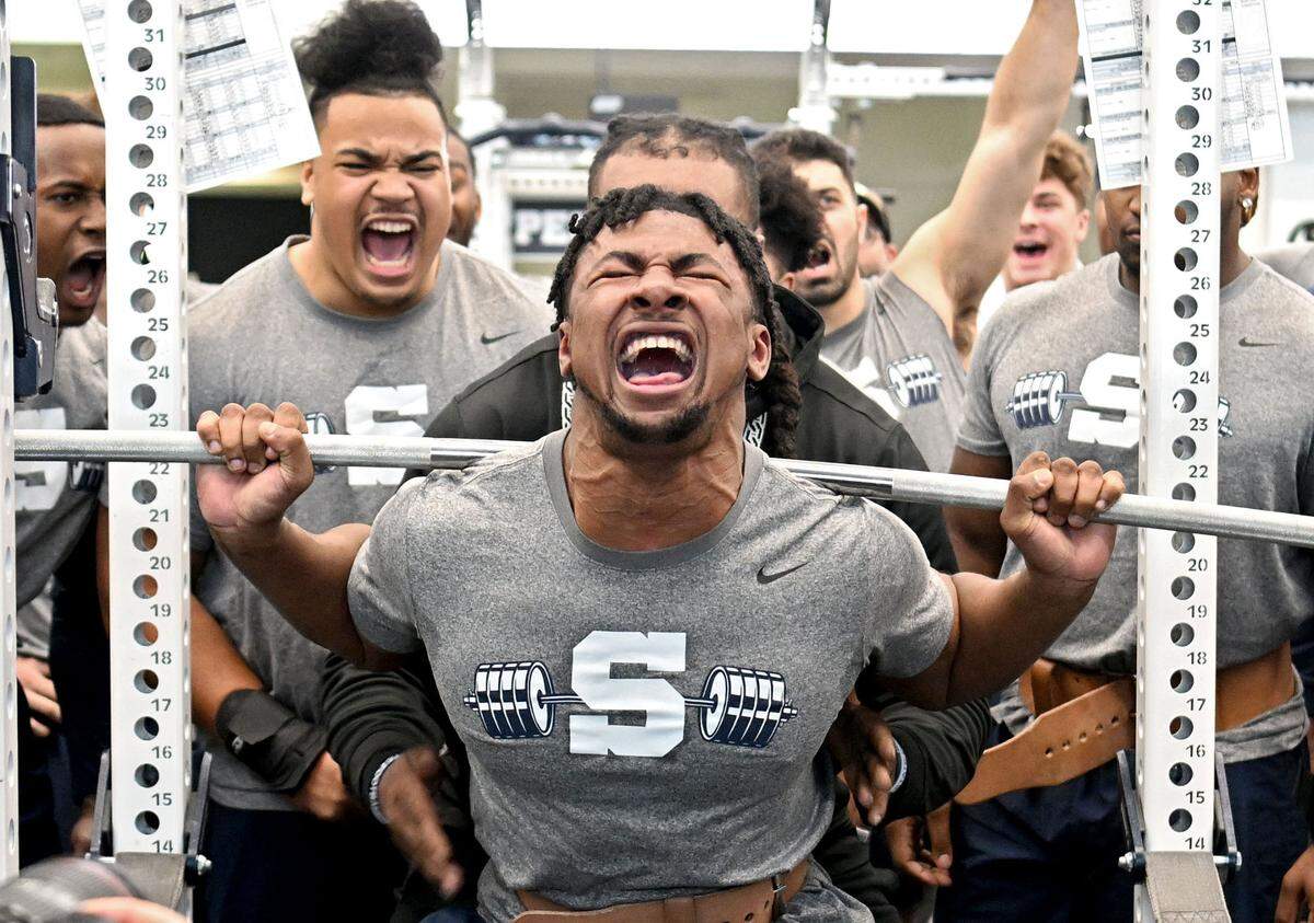 Penn State running back Nick Singleton is cheered on by teammates as he lifts 570 pounds 5 times during a winter workout on Thursday, Feb. 29, 2024. This photo won second place in the Sports Action Photo category at the 2025 Keystone Media Awards.