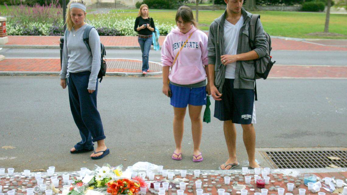 Students stop to view a makeshift memorial for Joe Dado along Pollock Road on Tuesday, September 22, 2009. CDT/Christopher Weddle
