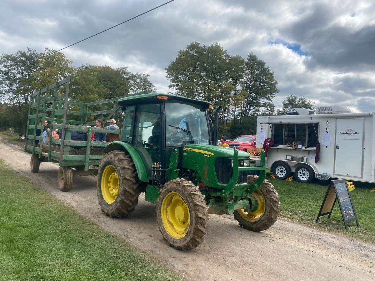 Families take a hayride to the pumpkin patch during Wasson Farm’s fall festival on Saturday, Oct. 8, 2022.