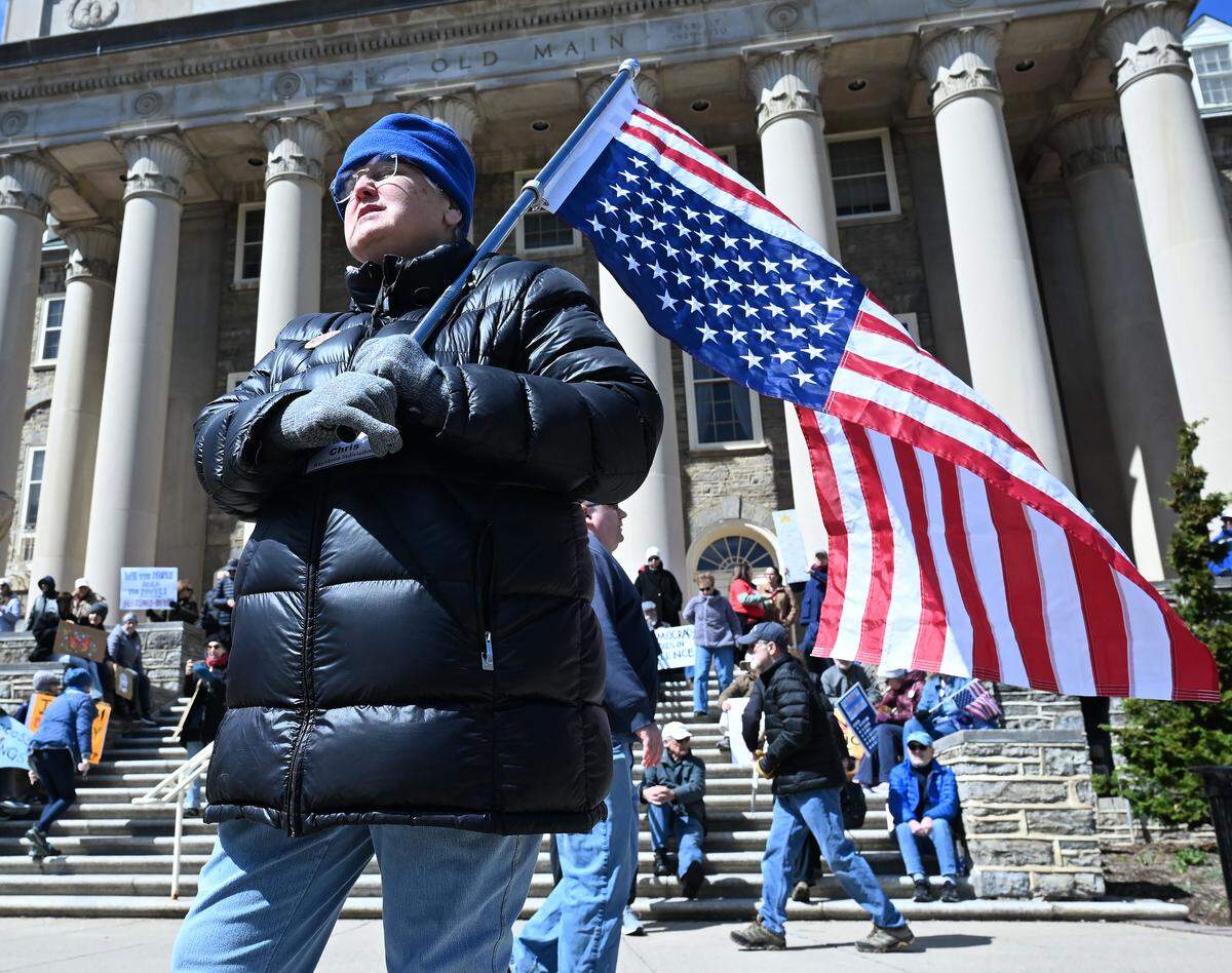 Many people carried signs and gathered on Old Main lawn for the No Kings anti-Trump rally on Saturday. An upside-down flag indicates a nation in distress.
