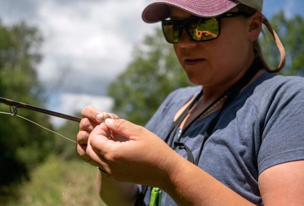 Tess Weigand picks a fly as she dry fly fishes along a section of Pine Creek on Wednesday, Aug. 24, 2022.