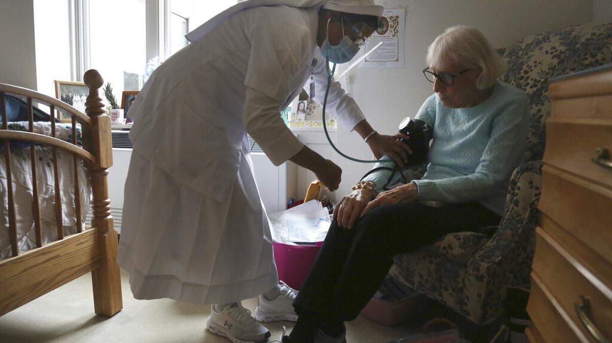Sister Rose Nellivila checks the blood pressure of Lorraine Catney, a resident of Villa Angela at St. Anne Home nursing facility in Greensburg, Pa., Thursday, March 25, 2021.