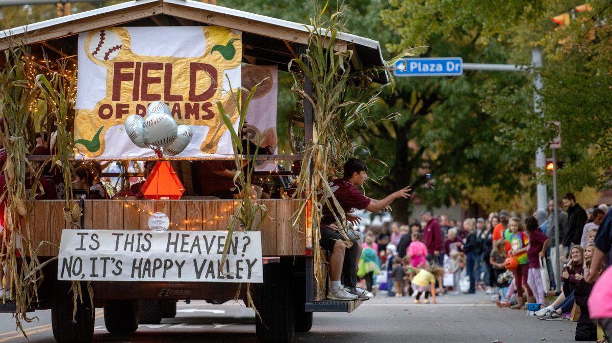 A player tosses candy to the crowd from the baseball team float in the State College Area homecoming parade on Thursday, Oct. 6, 2022.