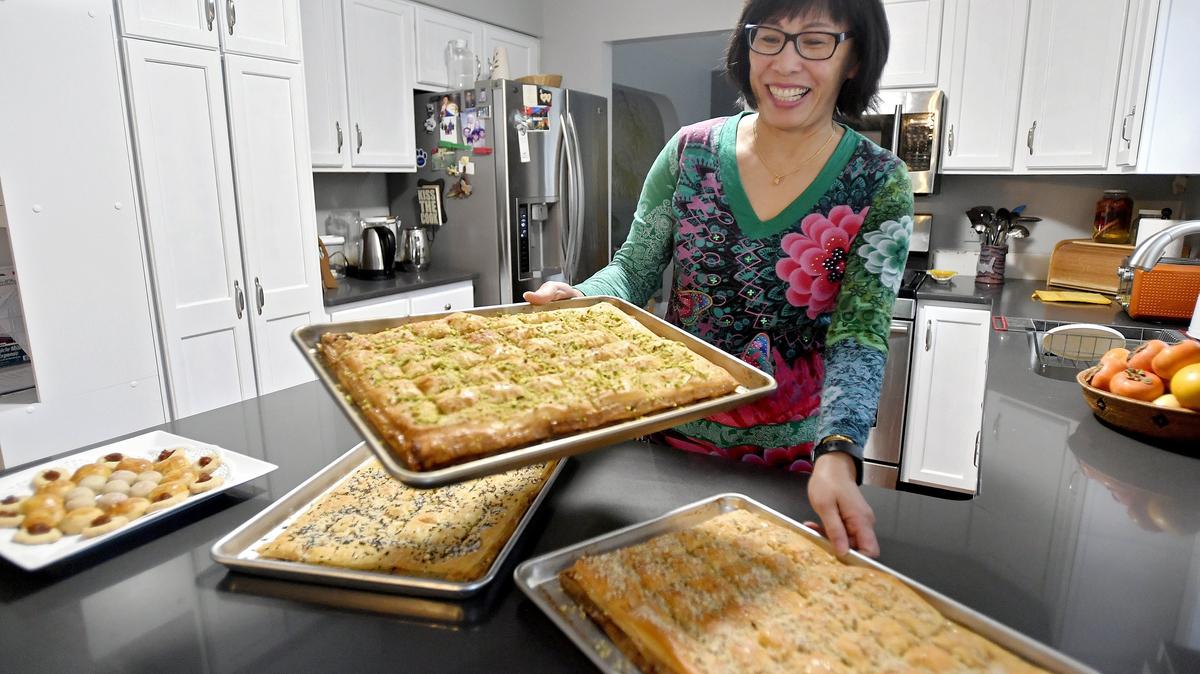 Ann Kusnadi of Koo-Weh Nana organizes several trays of fresh baklava on Monday, Nov. 26, 2018.