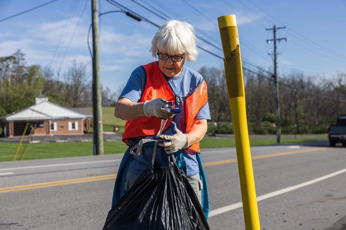 Volunteer Darlene Clark ties off a full trash bag in Pine Grove Mills, Pa., on Saturday, April 18, 2026. The ClearWater Conservancy organized volunteers across Centre County to clean up public green spaces.