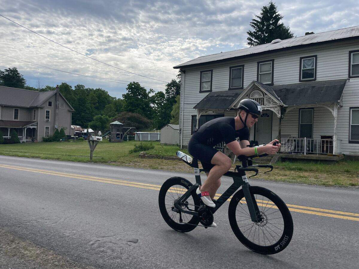 Jonathan Earley passes homes in Jacksonville on Sunday, June 14, 2026, during the Ironman 70.3 Pennsylvania Happy Valley North American Championship in Centre and Clinton counties.