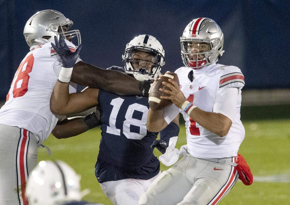 Ohio State quarterback Justin Fields takes his time making a pass as Penn State defensive end Shaka Toney tries to pressure him during the game on Saturday, Oct. 31, 2020 at Beaver Stadium.