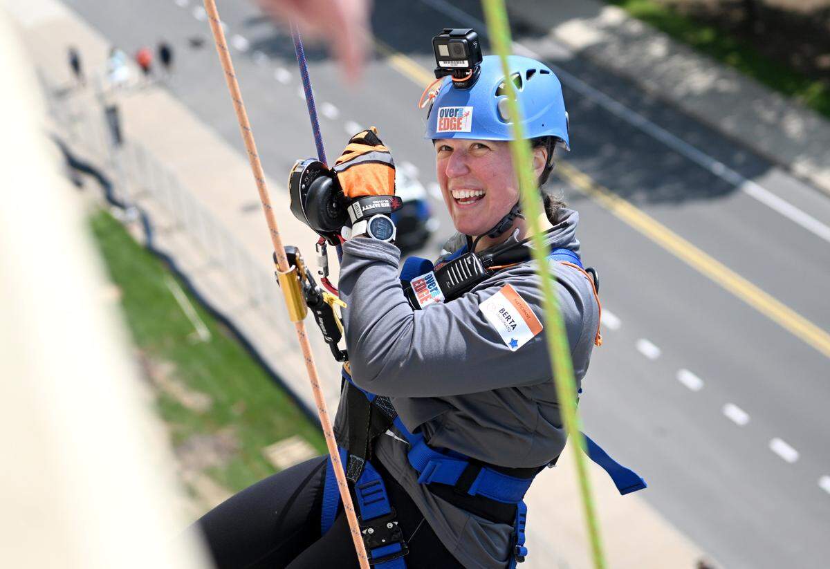 Berta DeDonato smiles as she rappels down the side of Beaver Stadium for the Centre County United Way Over the Edge fundraiser on Friday, May 19, 2023.