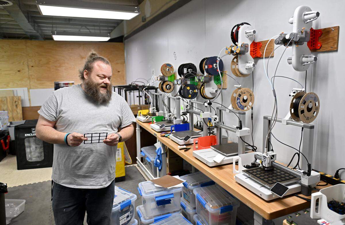 Daniel Henry talks Monday about some of the game accessories he 3D prints in his shop, Lizzy’s Toy Box in Bellefonte.