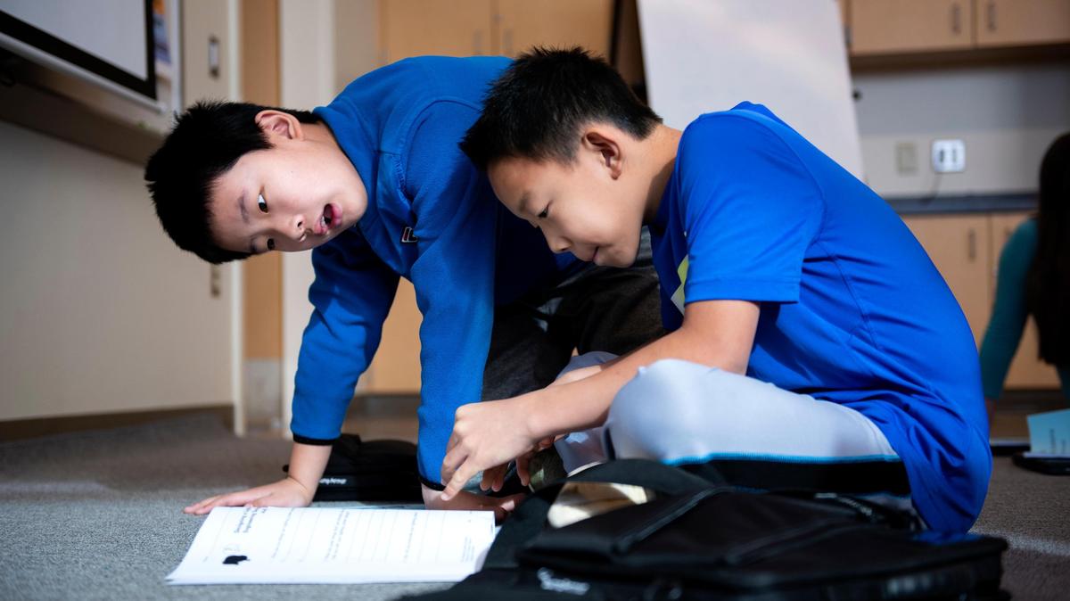 Two 5th grade students, William Liu and Bryan Wang, read the textbook before the STEM class on Oct. 17, 2018 at Ferguson Township Elementary School in State College, Pa. (Photo/Baidi Wang)