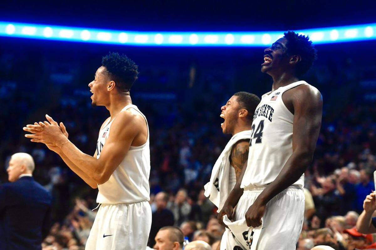 Penn State basketball players, fro left, Myreon Jones, Myles Dread and Mike Watkins cheer on their team against Maryland on Tuesday, Dec. 10 at the Bryce Jordan Center.