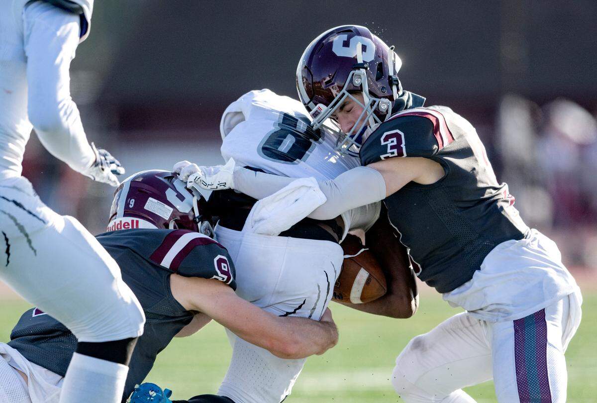 State College’s Owen Yerka and Ty Salazer stop Harrisburg’s Shawn Lee Jr. during the PIAA 6A semifinal game at Mansion Park on Saturday, Dec. 3, 2022.