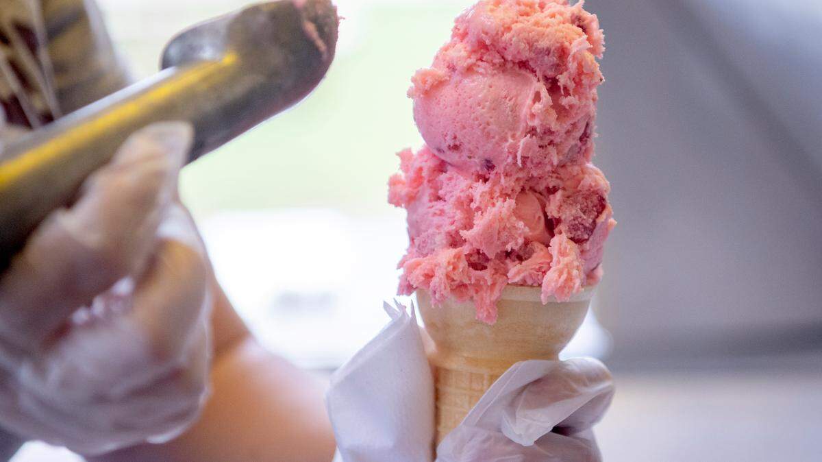 Nicole Wasson scoops a cone of strawberry ice cream Thursday at the Wason Farm Market ice cream trailer.