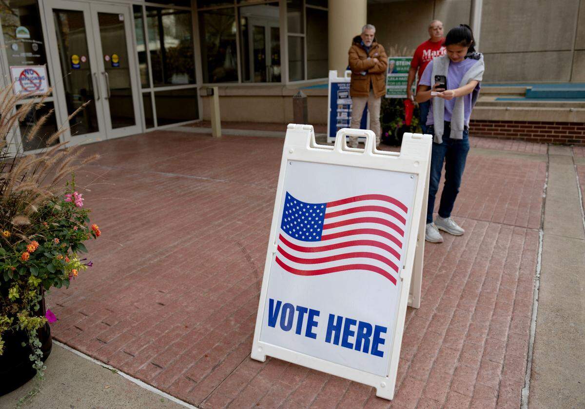 A voter stops to take a photo of her voting sticker as she leaves the State College Municipal Building on Election Day, Tuesday, Nov. 5, 2024.