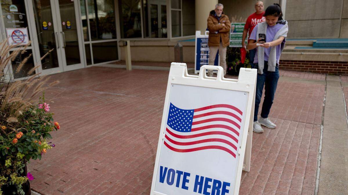 A voter stops to take a photo of her voting sticker as she leaves the State College Municipal Building on Election Day, Tuesday, Nov. 5, 2024.