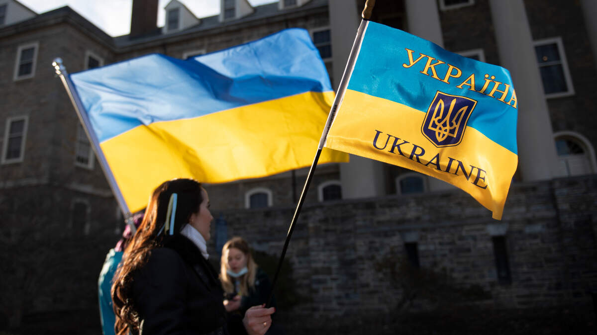 Nelia Mihai holds a Ukrainian flag Thursday during a rally hosted by the Ukrainian Society at Penn State in front of Old Main.