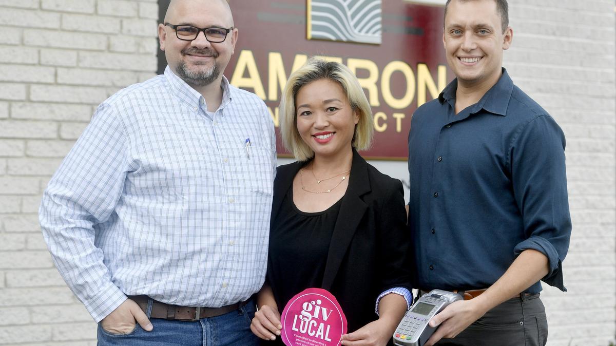 Giv Local co-founders Sam Buckley, Shizuka Buckley and Christian Baum post outside of Ameron Construction on Tuesday, Oct. 9, 2018.  Ameron Construction is the first company to use Giv Local, which donates a company’s credit card processing fees to a local nonprofit.