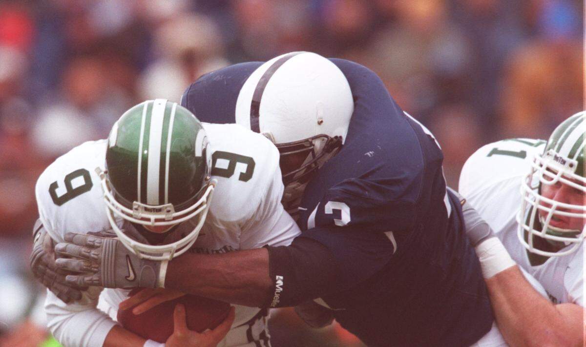 Spartan QB Jeff Smoker gets snuffed by Penn State’s Jimmy Kennedy early in the first quarter of a game.
