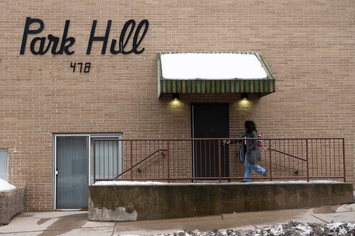 A woman walks into the Park Hill Apartments on Tuesday. The apartments will undergo renovations after being purchased by a Chicago-based real estate developer.