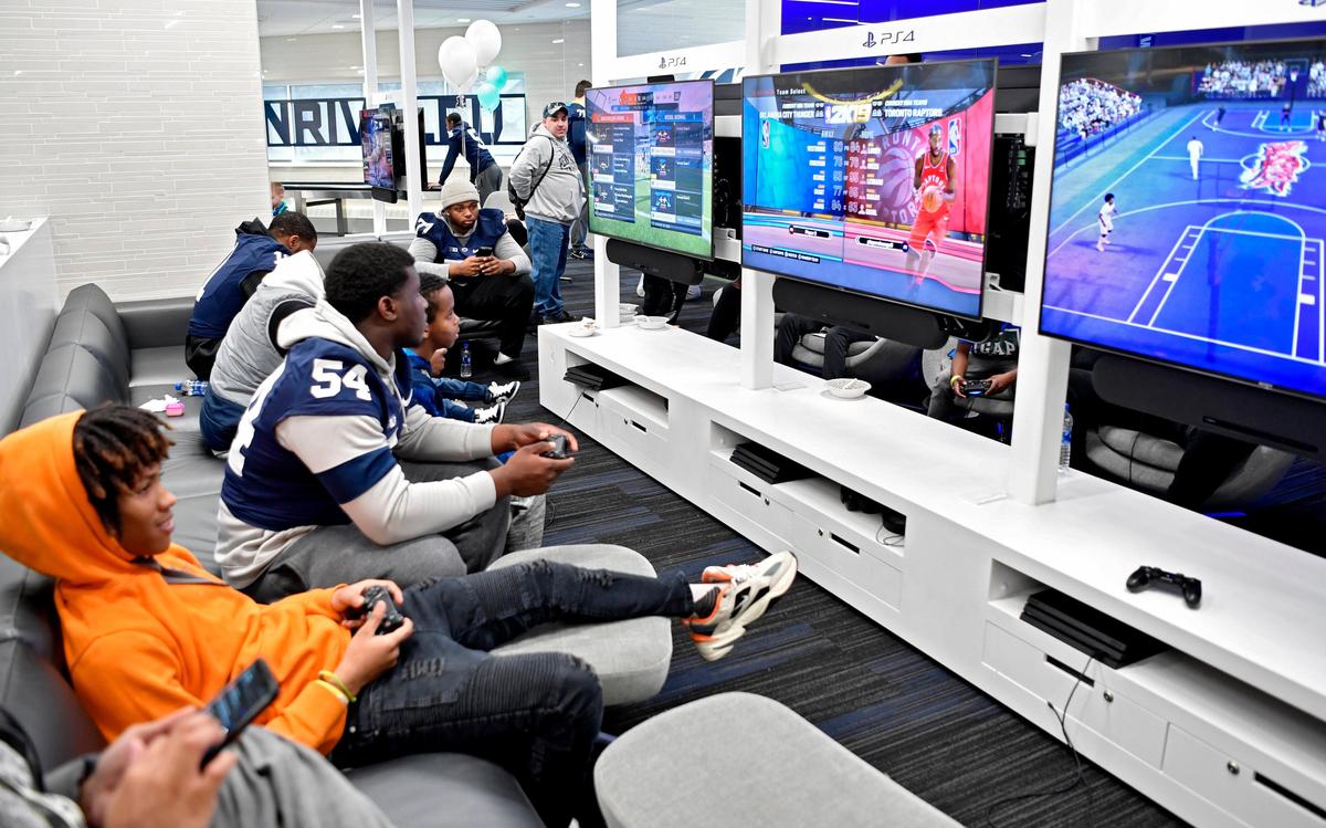 Penn State football players and Four Diamond families play video games together in lounge of the Lasch Building on Saturday, Feb. 22, 2020.