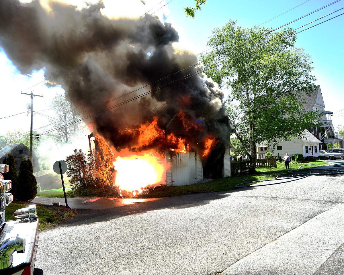 Firefighters wait to start battling a garage fire on East Potter Street due to live wires on Wednesday, May 8, 2024.