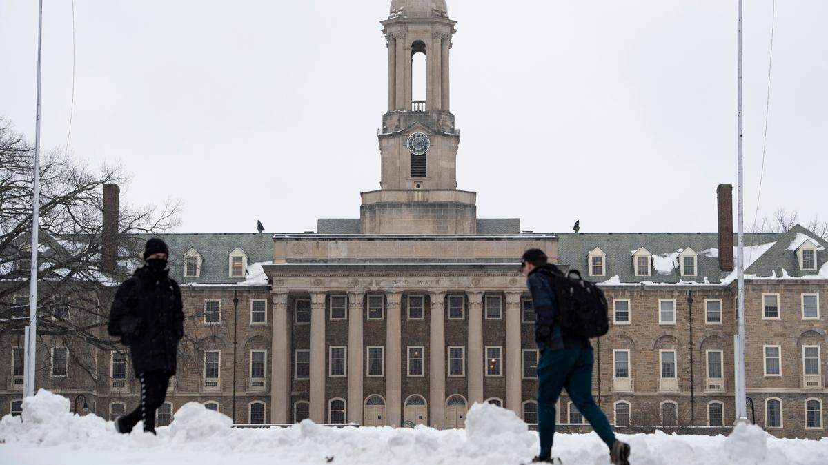 Students walk in front of Penn State’s Old Main on Jan. 18 in University Park.