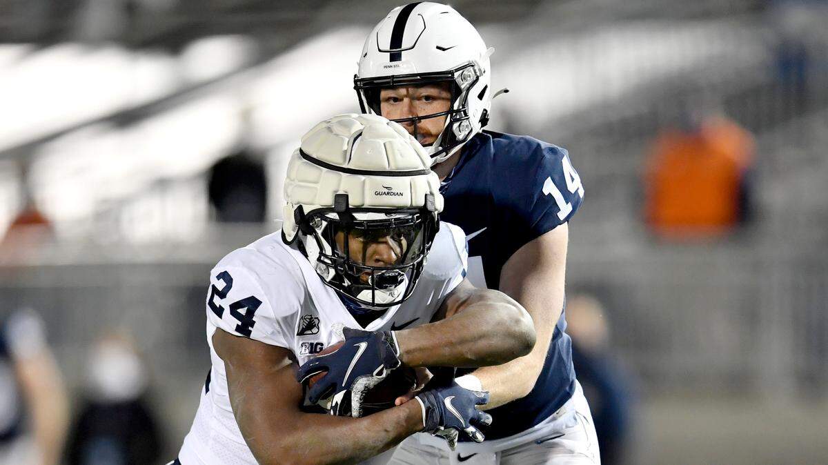 Quarterback Sean Clifford hands off to running back Keyvone Lee during Penn State football practice on Friday, April 23, 2021 at Beaver Stadium.
