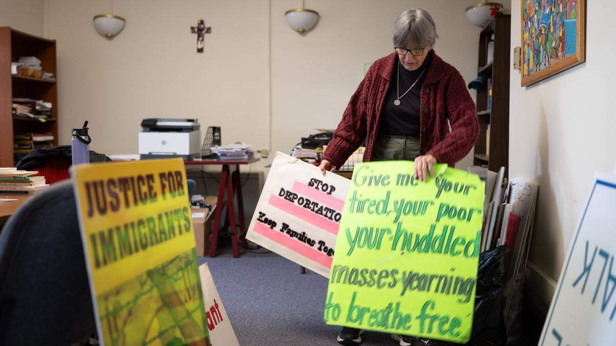 Benedictine Sister Anne McCarthy rifles through demonstration signs in Erie on Monday, March 30, 2026.
