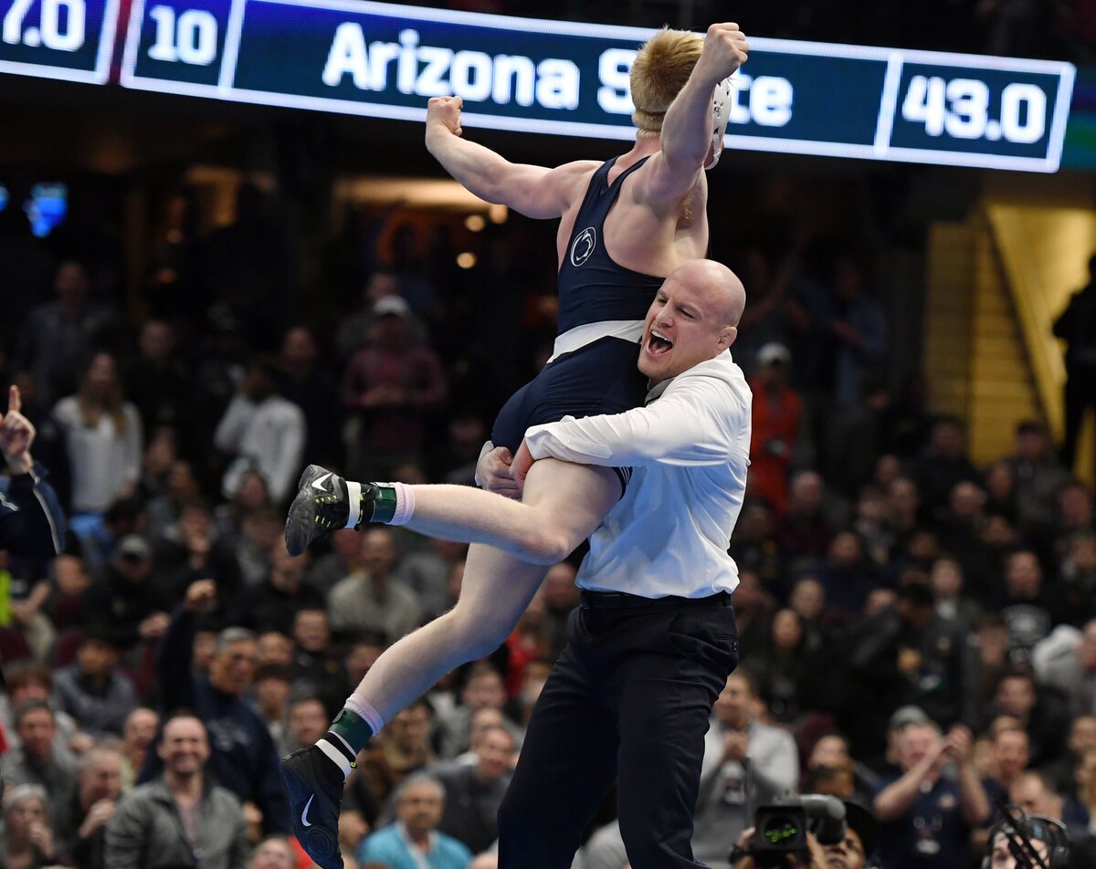 Penn State’s Bo Nickal jumps into head wrestling coach Cael Sanderson’s arms after pinning Ohio State’s Myles Martin in the 184 pounds finals during the NCAA Division I Wrestling Championships Saturday, March, 17, 2018 at the Quicken Loans Arena in Cleveland, Ohio.