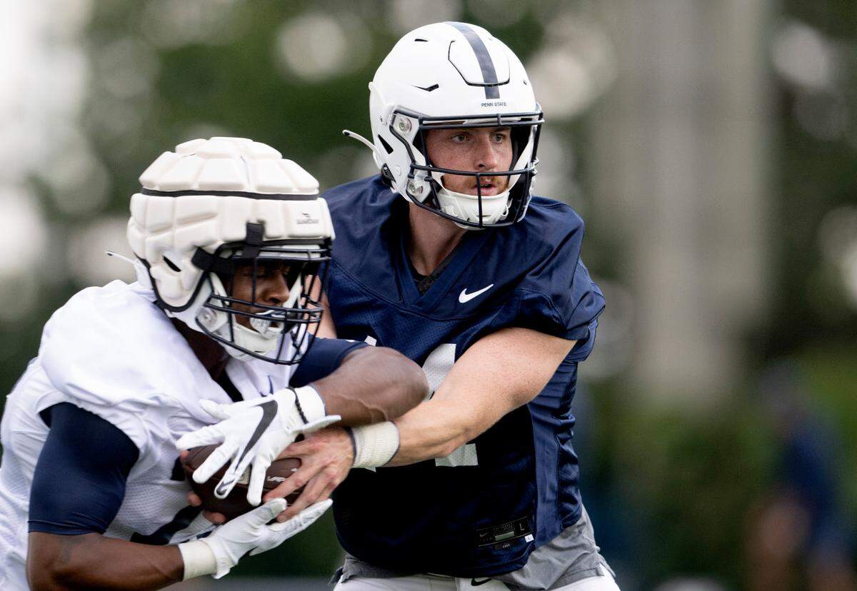 Penn State quarterback Sean Clifford hands the ball off during the first day of practice on Monday, Aug. 1, 2022.