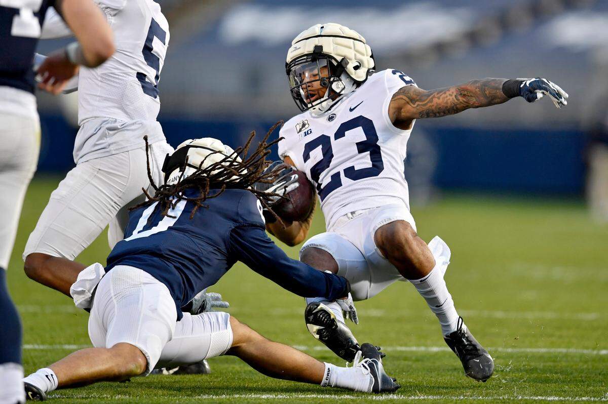 Penn State safety Jonathan Sutherland trips up Penn State running back John Lovett during practice on Friday, April 23, 2021 at Beaver Stadium.