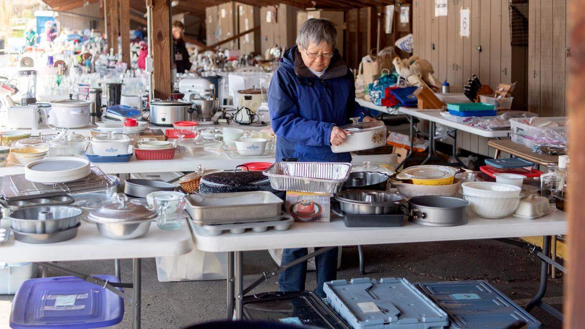 Emily Filling helps to put out items for the Foxdale Village yard sale on Thursday, April 28, 2022.