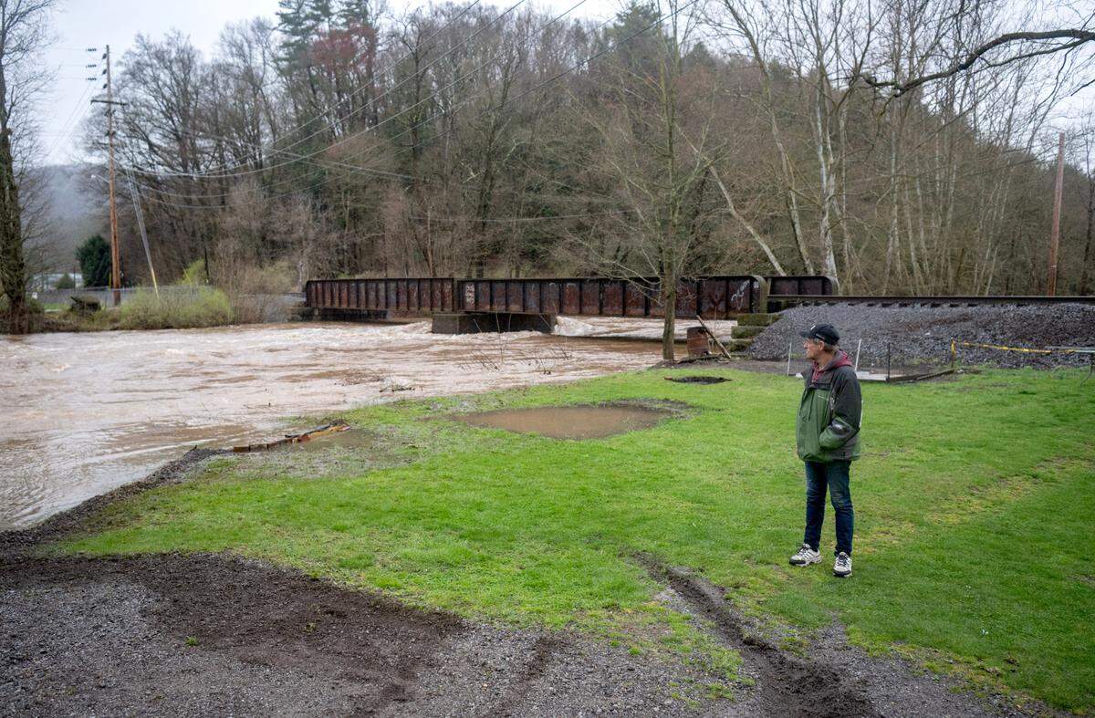 A homeowner watches as Moose Run starts to encroach his home along Front Street in Milesburg on Wednesday, April 3, 2024. Water was already coming in the basement.