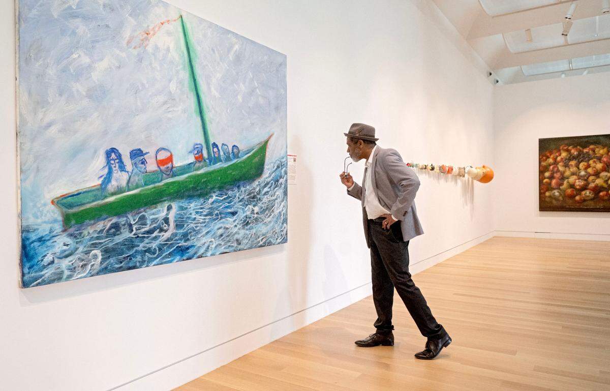 Dean of Penn State’s College of Arts and Architecture Stephen Carpenter II looks at the painting “Boat People” by Lawrence Ferlinghetti at the new Palmer Museum of Art on Wednesday, May 29, 2024.